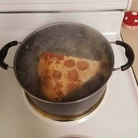 A pizza in a pot of boiling water